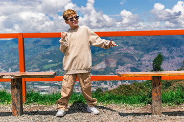 Boy playing and smiling outdoors in a sunny natural landscape