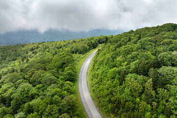 Road trip driving in Tennessee Appalachian mountains. Winding parkway in mountain forest with green canopies in summer rain season