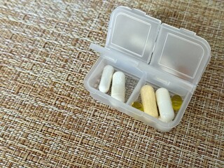 The weekly transparent pillbox is designed for convenient and efficient daily storage of dietary supplements and tablets. It has compartments with various types of capsules for administration.