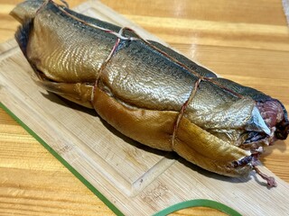 Cold hot smoked mackerel, beautifully laid out on a wooden chopping board, is ready for cooking and serving and is perfect for culinary themes.