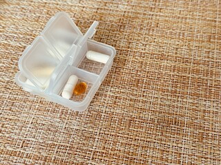 The weekly transparent pillbox is designed for convenient and efficient daily storage of dietary supplements and tablets. It has compartments with various types of capsules for administration.