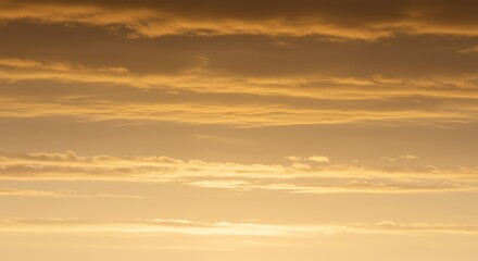 Fototapeta premium Serene cloudscape at sunrise showcasing soft golden hues and gentle gradients