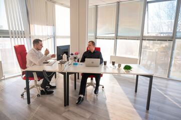 Two Caucasian men working in an office. 