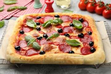 Tasty homemade pizza and ingredients on grey table, closeup