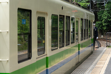 Eizan Railway train departs Demachiyanagi Station, heading into scenic northern Kyoto hills.