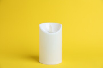 Decorative flameless LED candle on yellow background