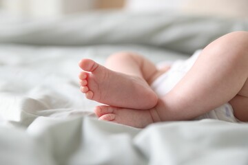 Cute newborn baby lying on bed, closeup