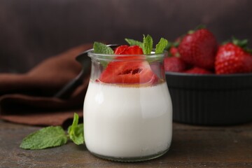 Tasty panna cotta with caramel, strawberries and mint on wooden table, closeup