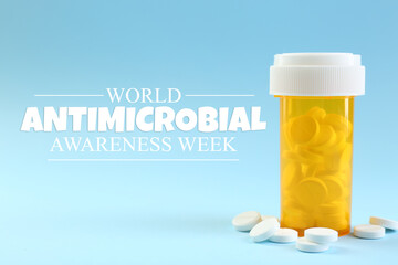 World antibiotic awareness week. Bottle and scattered pills on light blue background