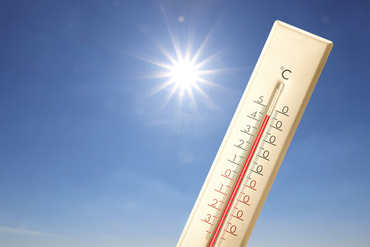 Extremely high temperature on thermometer against blue sky on sunny day. Summer weather