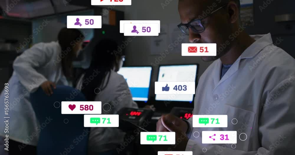 Poster male scientist tapping tablet and tracking rising media icons in lab with team viewing monitors