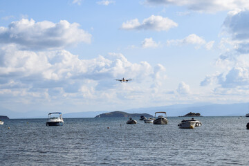 Commercial airplane coming in to land over the harbor at Skiathos International Airport, Greece....