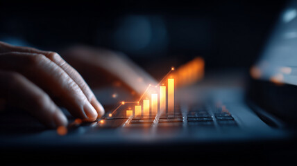 Hands typing on a laptop keyboard while a luminescent bar graph ascends, representing online business success through data-driven growth strategies.

