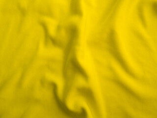 Yellow wavy fabric background. Wrinkled cloth