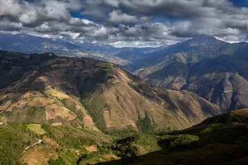 Terraced fields and patchwork farmland unfold beneath the imposing Andes near Kuelap fortress in Amazonas, Peru. Generations of local farmers have shaped this landscape.