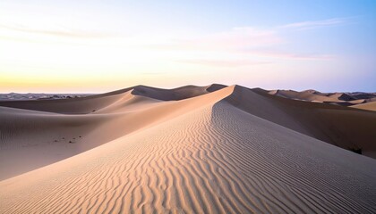 Rolling Sand Dunes Under A Pastel Sunrise Sky Displaying Golden Light Across The Textured Desert Landscape
