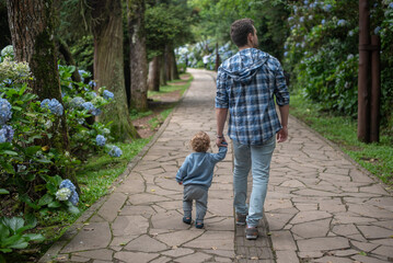 Father and baby son taking a walk on a path at Lago Negro - Gramado - Rio Grande do Sul - Brazil