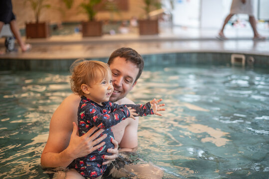 Father and baby son having fun in a kiddie pool