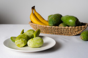 Peeled prickly pears and bananas ready to eat on white table