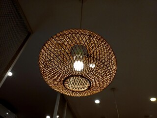 The light of the lamp in the hanging shade made of rattan crafts