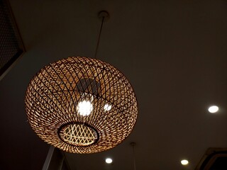 The light of the lamp in the hanging shade made of rattan crafts