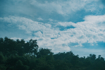 Obraz premium Bright blue sky with white clouds and glowing sun for background, texture, nature and design concepts, 눈부신 태양과 흰 구름의 파란 하늘 배경, 텍스처, 자연, 디자인 콘셉트 활용