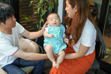 In June 2025, on a sunlit terrace, a Japanese father in his thirties and mother in their twenties...