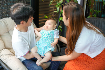 In June 2025, on a sunlit terrace, a Japanese father in his thirties and mother in their twenties...