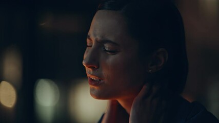 Closeup overworked freelancer massaging neck at dark apartment workplace. 