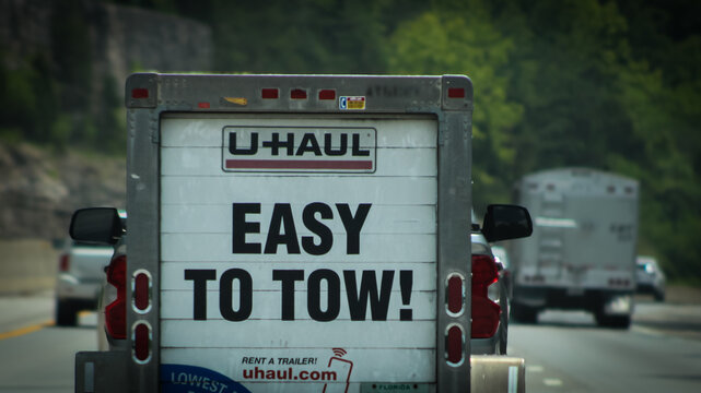 Interstate Hwy 75, USA - June 2025: The back of a U-Haul trailer from a passenger view on the road. U-Haul specializes in moving truck, trailer, and self-storage rentals. For Editorial Use.