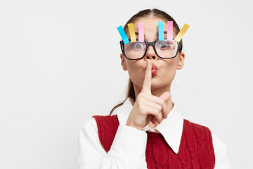 woman with colorful clips on glasses making shushing gesture, playful expression, minimalist...