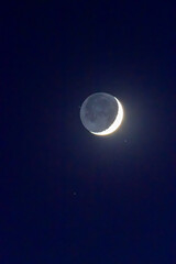 Crescent Moon Illuminated with Earthshine Against Night Sky