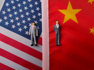 Top view miniature people on a us and china flag background
