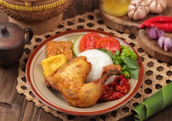Pecel ayam or penyet ayam or fried chicken in Indonesia is the name of a typical Javanese food consisting of fried chicken and tomato sauce.