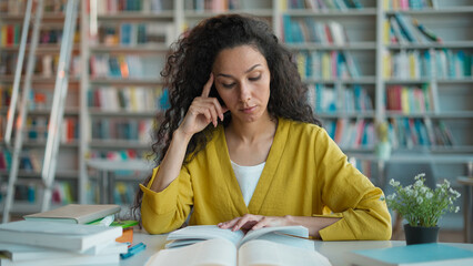 Latin Hispanic woman reading book learning student preparing exam studying tired close textbook...
