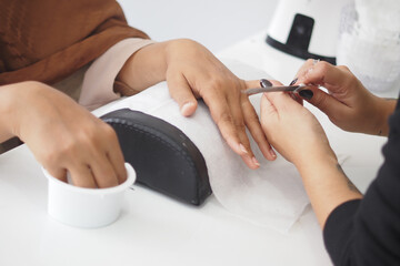 Nail technician offers manicure to a client in a salon