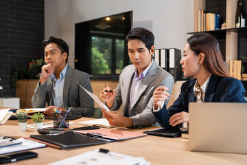 business partners discussing documents and ideas at meeting. Coworkers discussing business risks while working in the modern office.