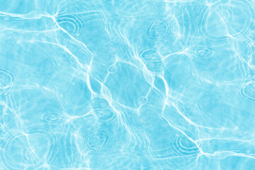 Blue water with ripples on the surface. Defocus blurred transparent blue colored clear calm water surface texture with splashes and bubbles. Water waves with shining pattern texture background.