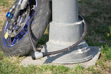Motorcycle secured with lock against a street pole