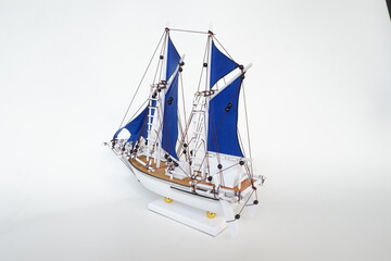 Miniature of a Traditional sailing boat made from wood and has blue sail