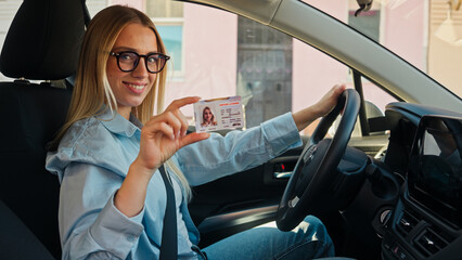 Happy successful Caucasian woman new car auto automobile transport vehicle driver pass exam showing...