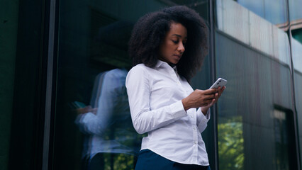 African American woman female girl thinking decision pondering urban city user mobile phone...