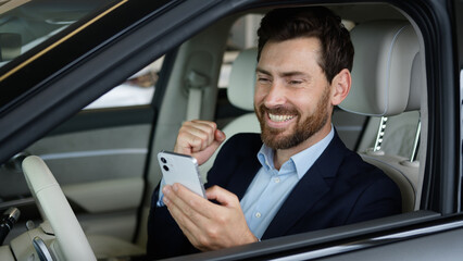 Excited Caucasian man businessman car happy using mobile phone smartphone achievement guy celebrate...