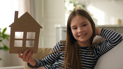 Caucasian European happy little girl holding cardboard paper home smile house domestic life child...