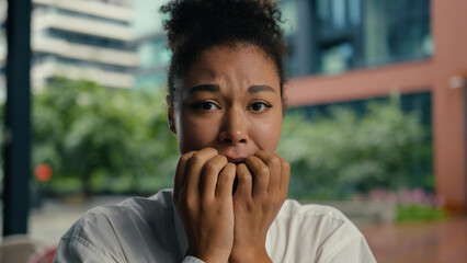 Close up face confused puzzled African American woman girl businesswoman business city bite lip...