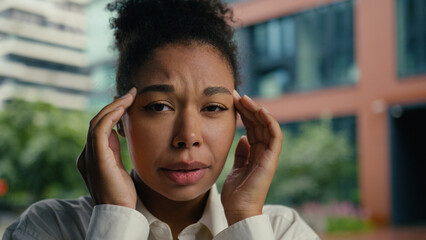 Close up face African American woman massaging temples headache migraine female girl businesswoman...