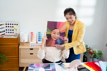 Young Asian woman doing personal color diagnosis by Face frames Color Season Kit for determining...