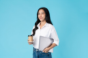Cheerful beautiful Asian woman holding laptop and coffee cup on blue background.