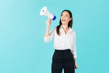 Beautiful Asian woman holding megaphone and shout on blue background.