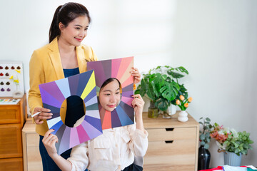 Young Asian woman doing personal color diagnosis by Face frames Color Season Kit for determining...